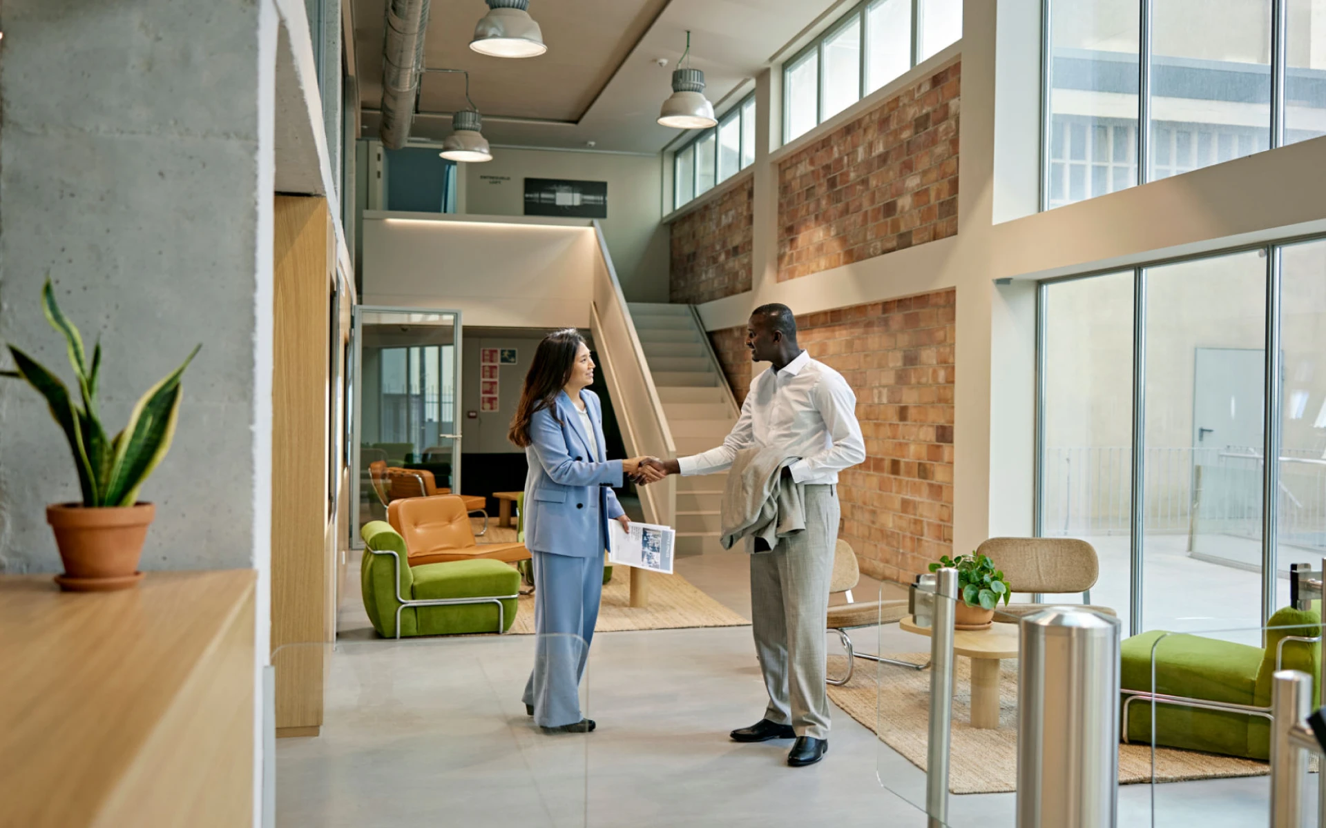 Business handshake in modern office lobby