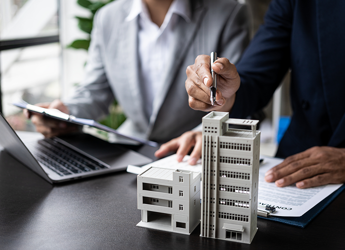 Businessmen reviewing architectural plans with models