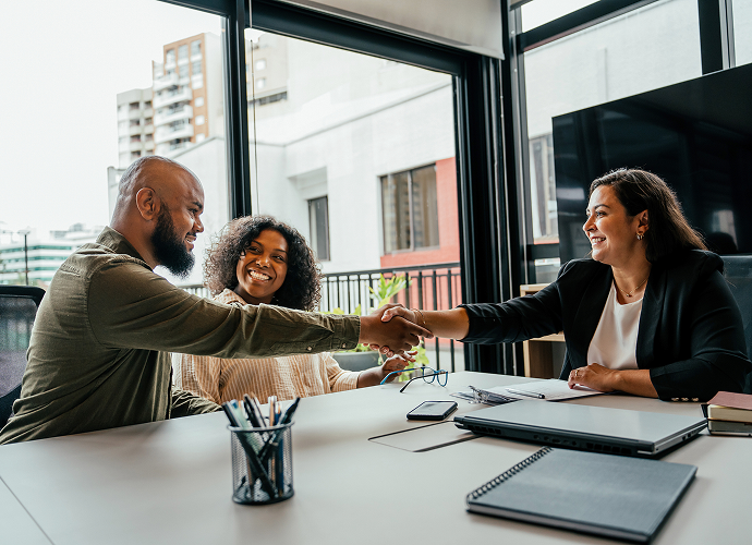 Smiling colleagues shaking hands in agreement